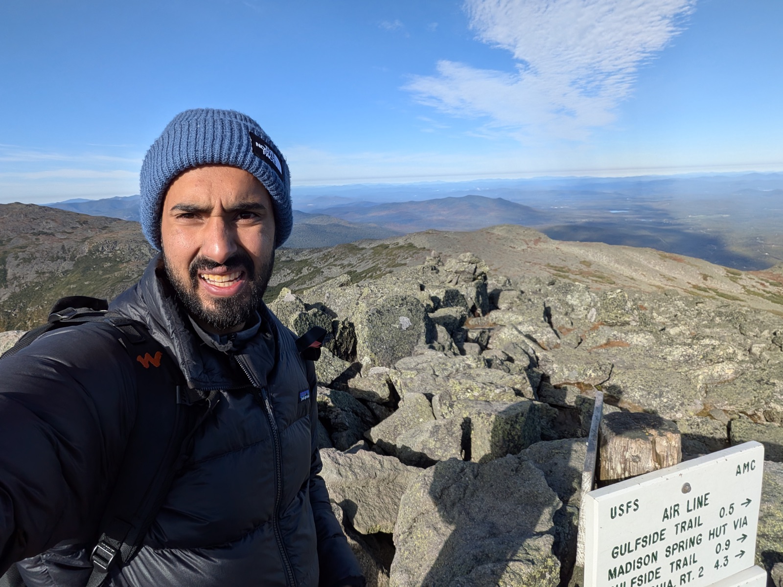 Selfie at a USFS trail sign on an open rocky ridge