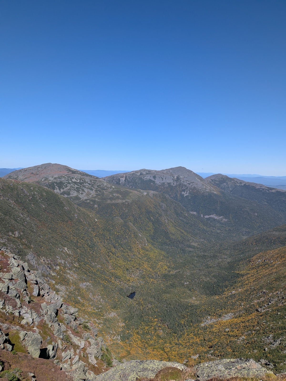 View across a ravine to a rocky ridge, early fall color below